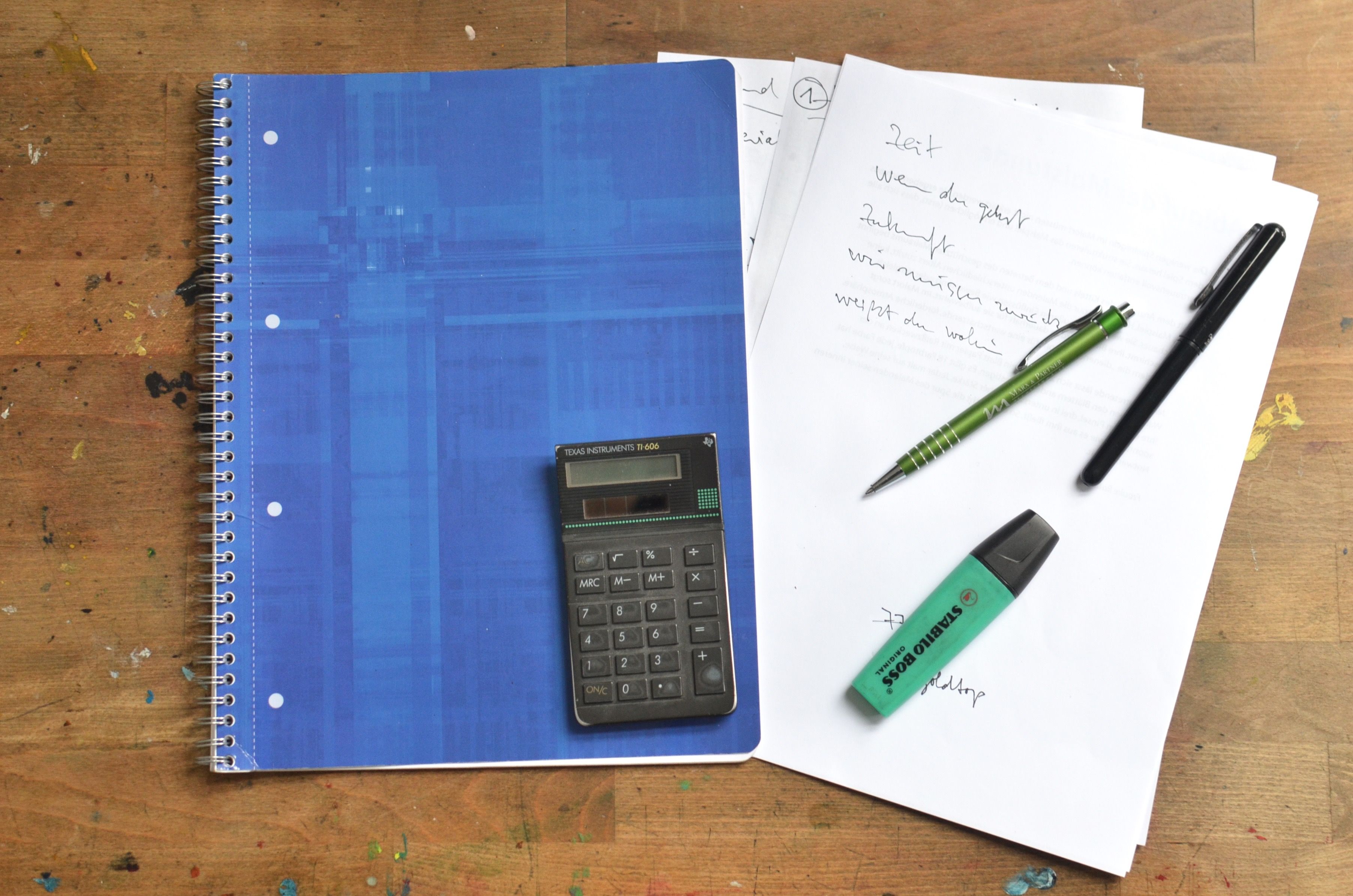 Office desk with notebook, calculator and pens laid out, representing organising data for a carbon accounting checklist