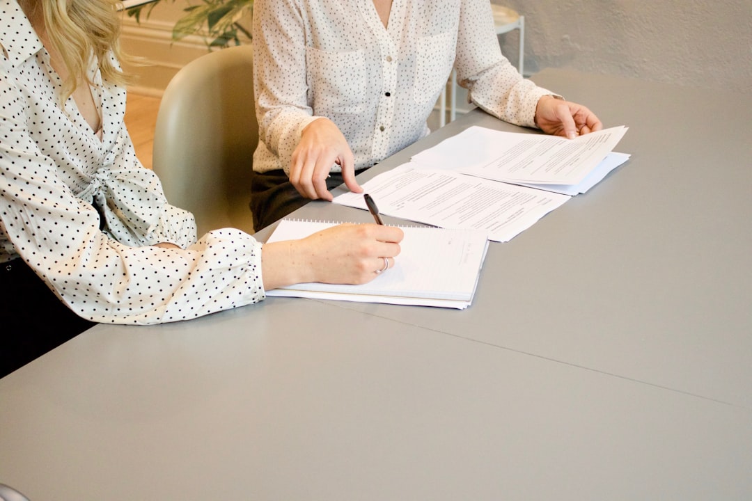 Two colleagues reviewing pages of a sustainability report together at a table