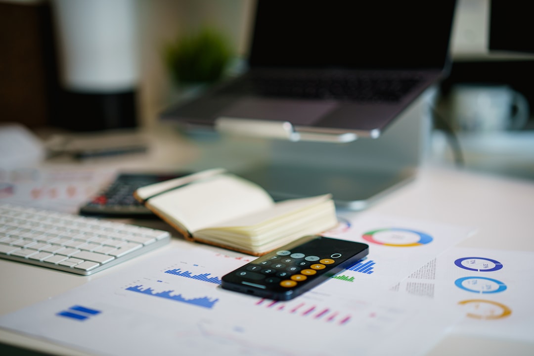 Close-up of emissions charts, a notebook, and a calculator on a desk, representing the data side of carbon accounting