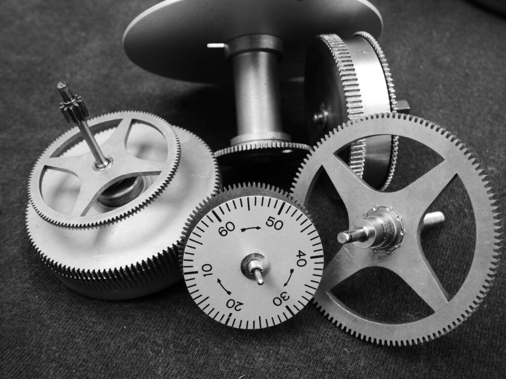 Close-up grayscale photo of interlocking industrial gears, representing friction and lubrication in machinery