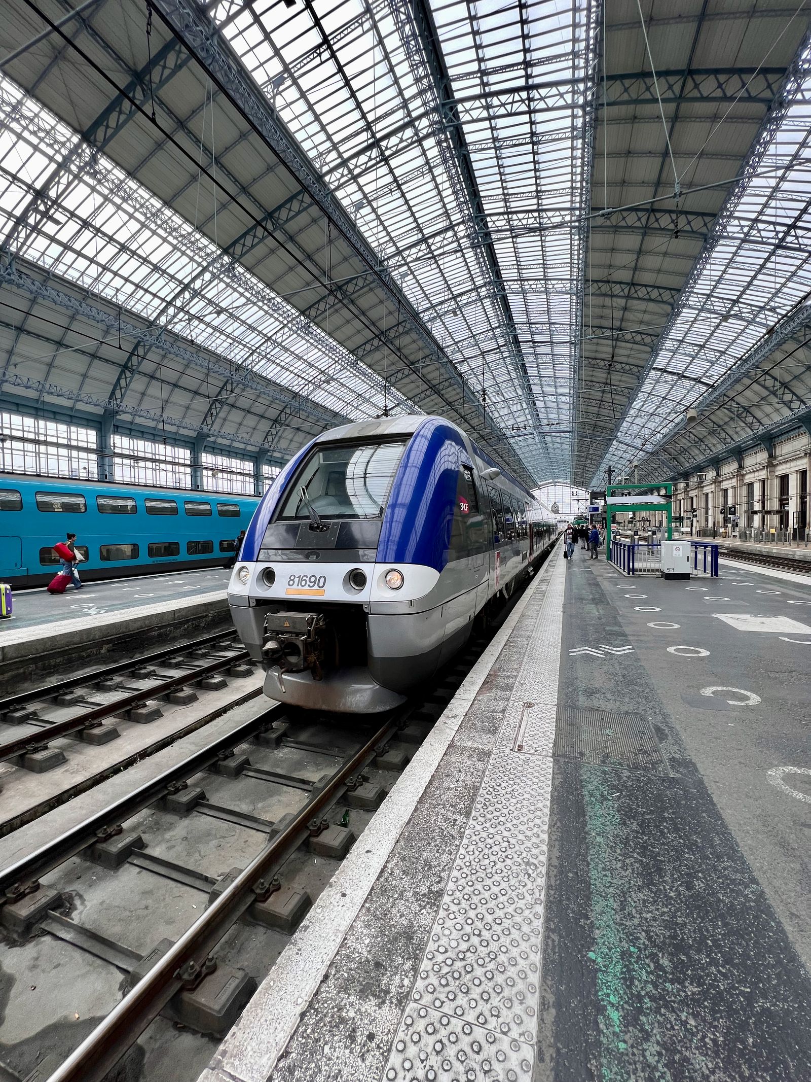 Modern electric passenger train at a glass-roofed railway station, representing clean rail mobility