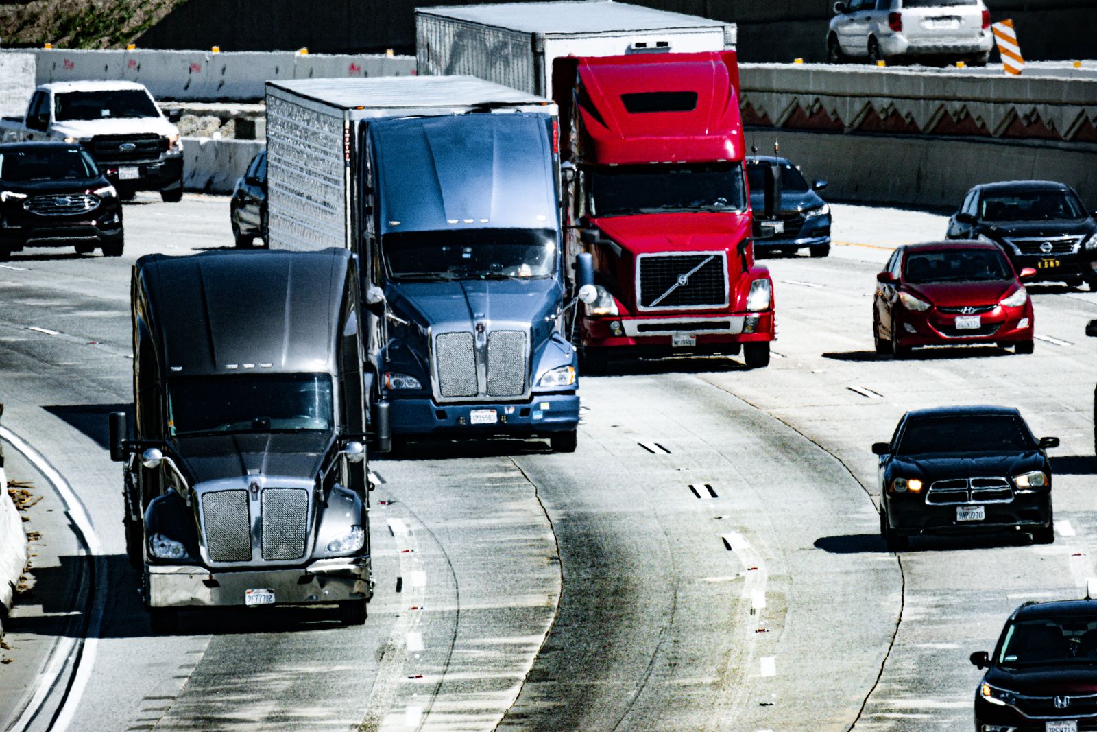Trucks and cars travelling together on a busy multi-lane highway