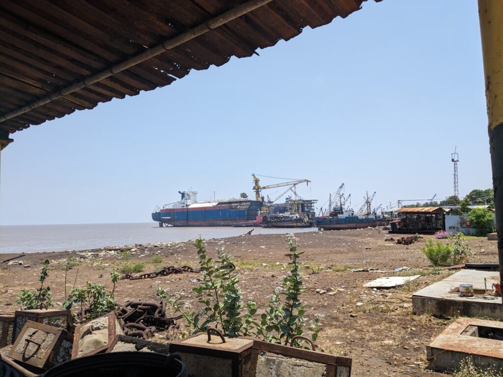 Dismantled ship hulls and cranes at the Alang ship recycling yard on the Gujarat coast, India