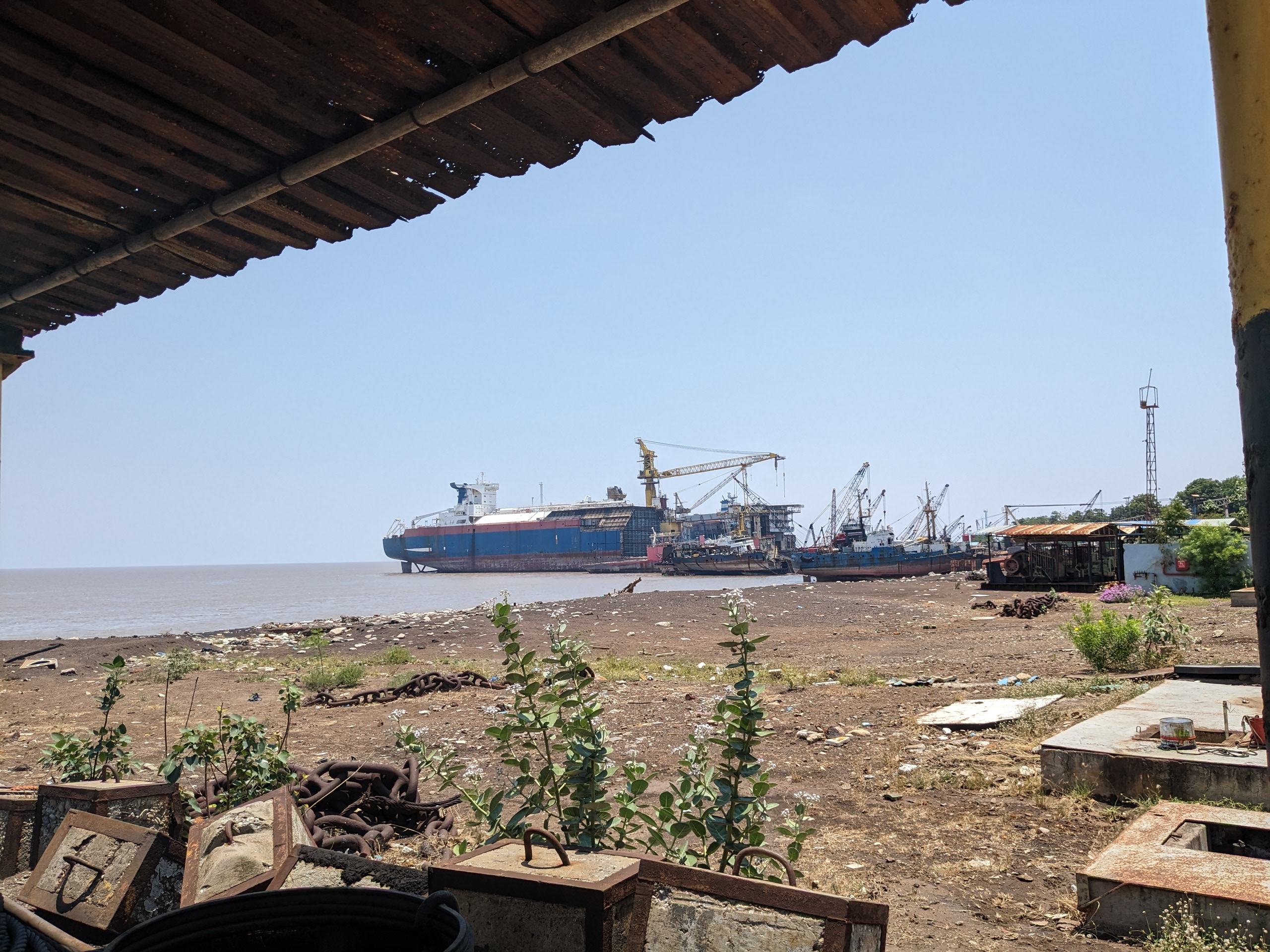 Dismantled ship hulls and cranes at the Alang ship recycling yard on the Gujarat coast, India