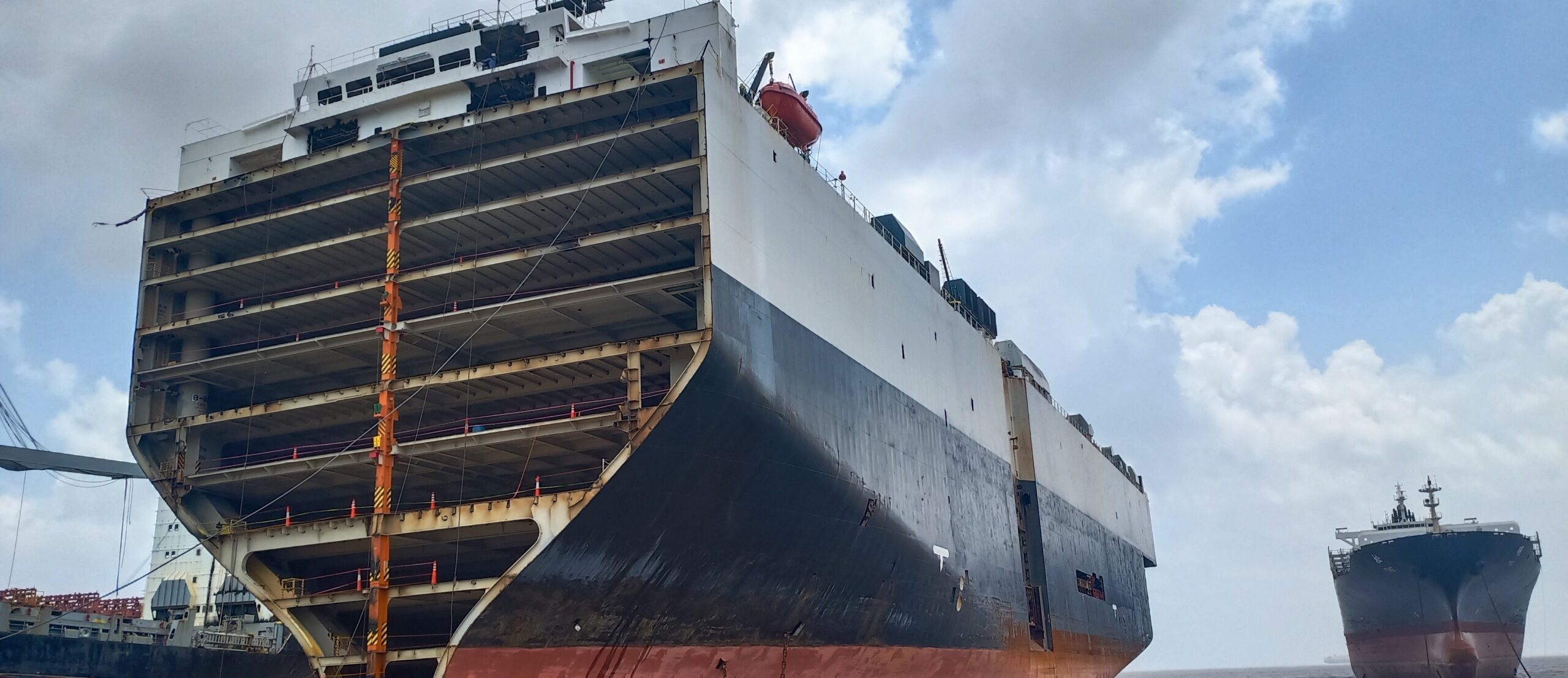 Large end-of-life cargo vessel partially dismantled and beached at a ship recycling yard in India, steel structure exposed