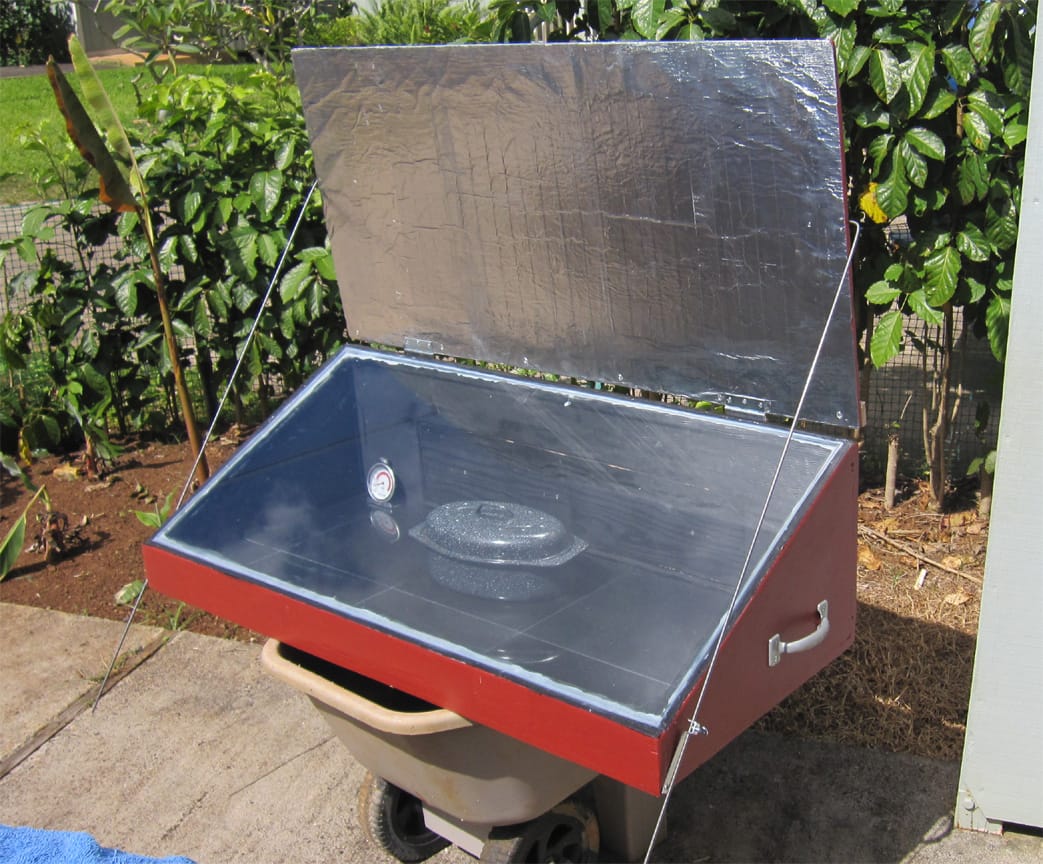 Box-type solar cooker with insulated lid and glass top used for slow solar cooking