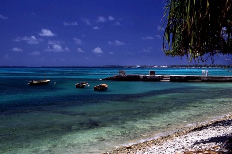 Turquoise lagoon, small boats and a concrete jetty on the coast of Funafuti Atoll, Tuvalu