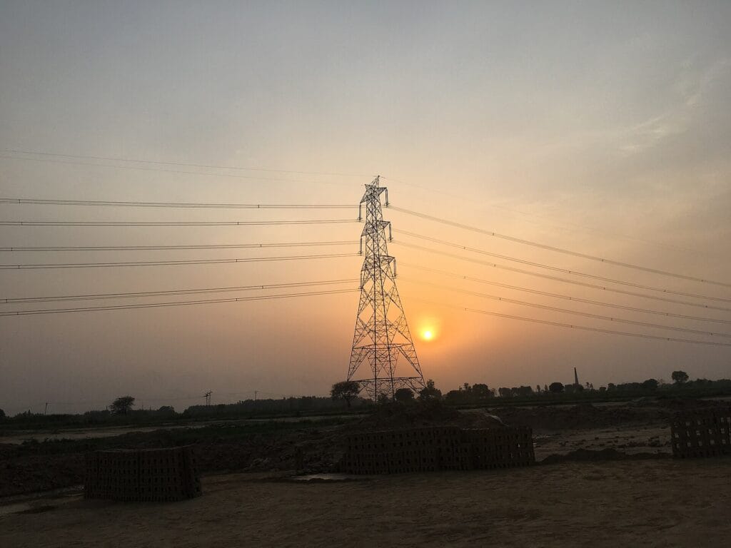 Green Energy Corridor transmission tower and power lines at sunset in India
