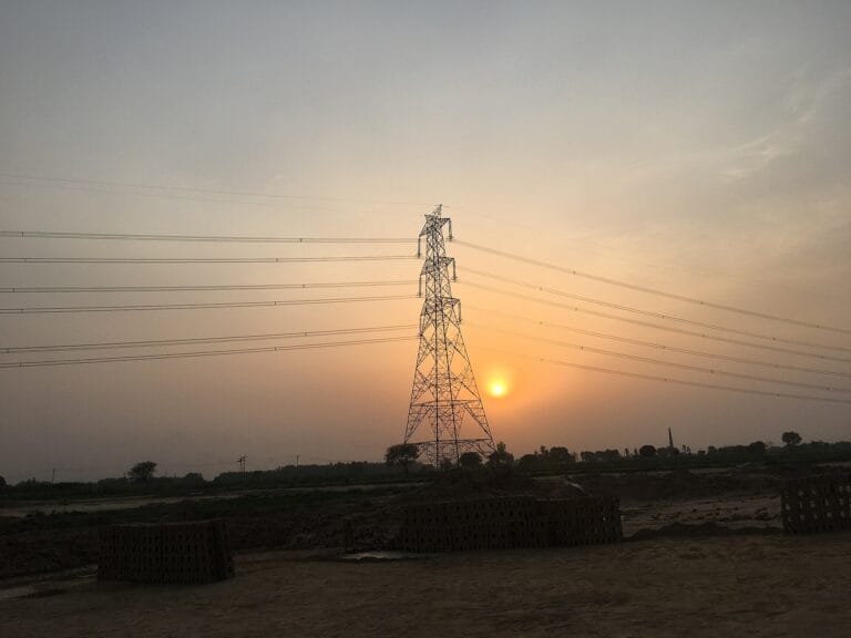 Green Energy Corridor transmission tower and power lines at sunset in India