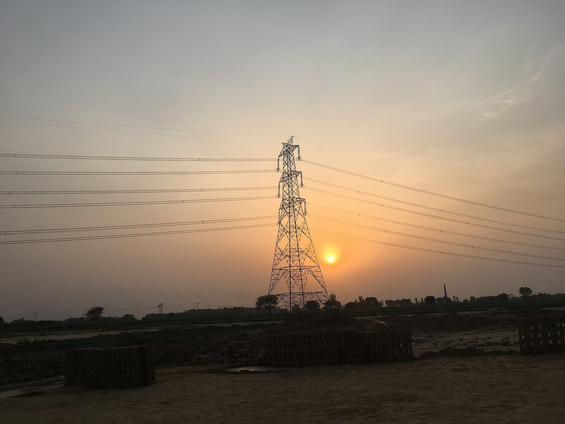 Green Energy Corridor transmission tower and power lines at sunset in India