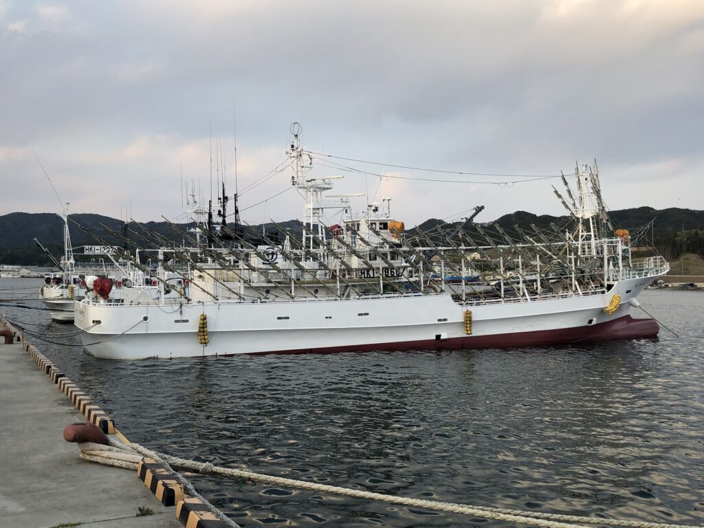 Squid-fishing boat with rows of lamps moored in a harbour