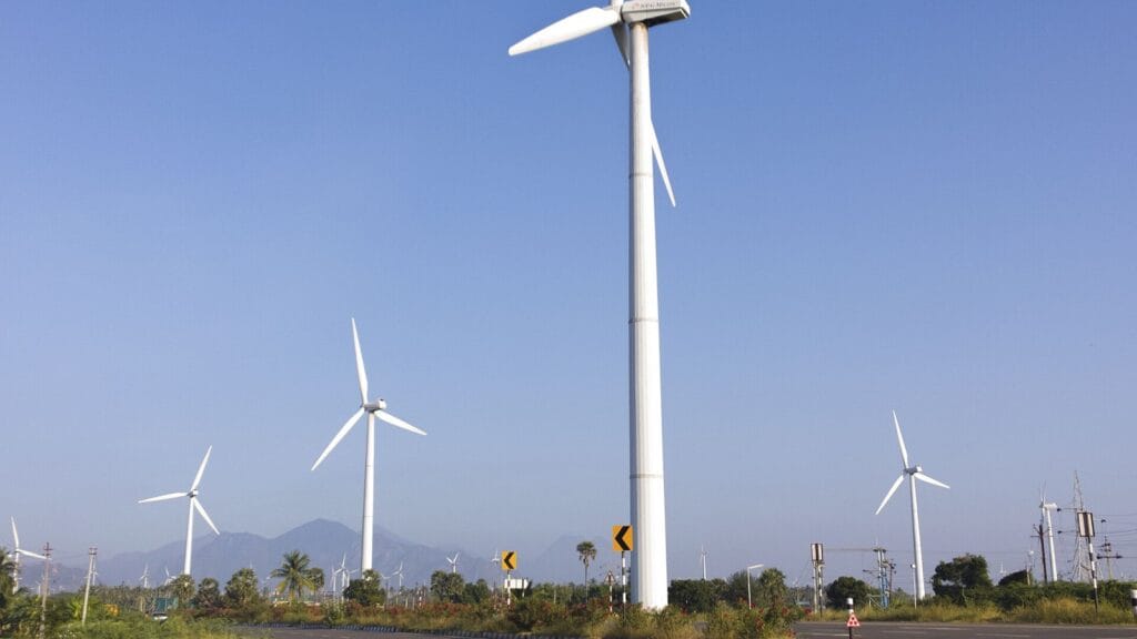 Wind turbines on a coastal road, showing wind energy in India, in Tamil Nadu