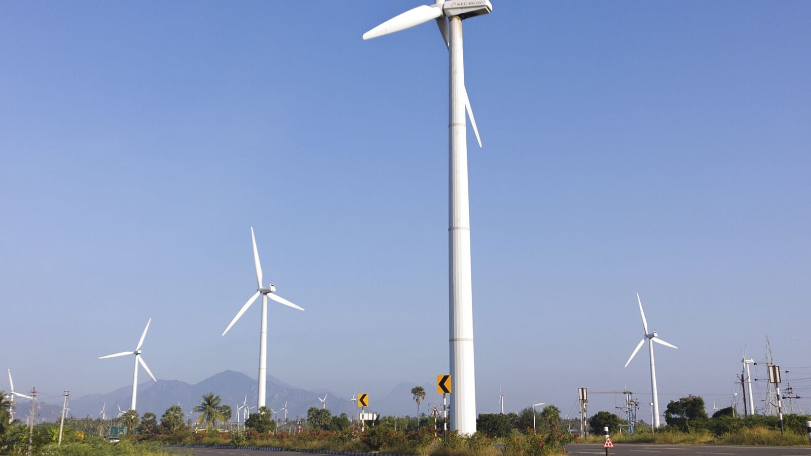 Wind turbines on a coastal road, showing wind energy in India, in Tamil Nadu